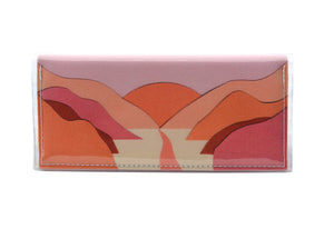 This is an image of the rear of a Kitty Came Home bifold purse clutch in 'The golden dawn' design by Satin and Tat. A path wends through a valley of pink and orange hills towards an orange rising sun. This is the standard size.