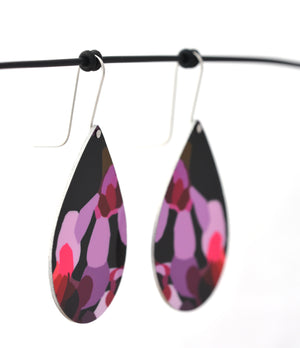 Droplet earrings featuring pink Geraldton Wax flowers on a black background. The aluminium droplets are approximately 40mm long and 29mm wide. The 15mm long shepherds hooks are surgical stainless steel.