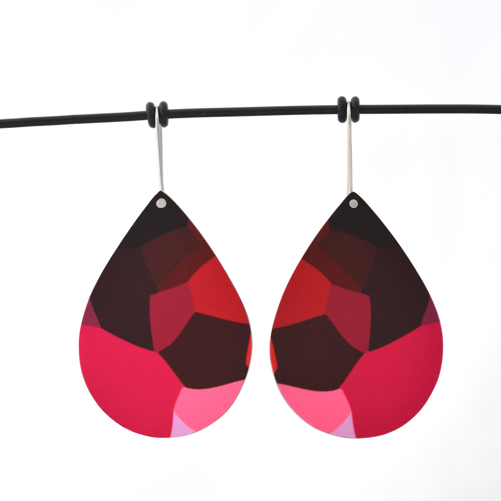 Pink facet-shapes droplet earrings; designed from the organic details inside Geraldton Wax flowers. The aluminium droplets are approximately 40mm long and 29mm wide. The 15mm long shepherds hooks are surgical stainless steel.