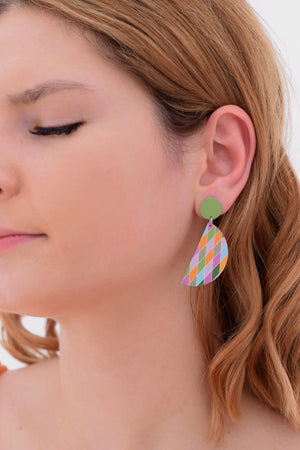 The is a photograph of a woman wearing the harlequin earrings. 36 millimetre diameter semi-circles in a colourful harlequin pattern dangle from 12 millimetre green circle studs. The colours are pinks, blue, greens and yellows and originate from a photograph of daisies.