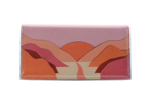 This is an image of the rear of a Kitty Came Home bifold plus purse clutch in 'The Golden Dawn' design by Satin and Tat. A path wends through a valley between pink and orange hills towards a rising orange sun. This is the large size.