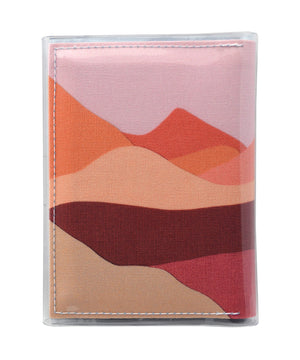 This is an image of the rear of a Kitty Came Home A6 journal in the 'Lilly of the valley' design by Satin and Tat. A landscape of orange, pink, burgundy and magenta hills beneath a dusty pink sky.